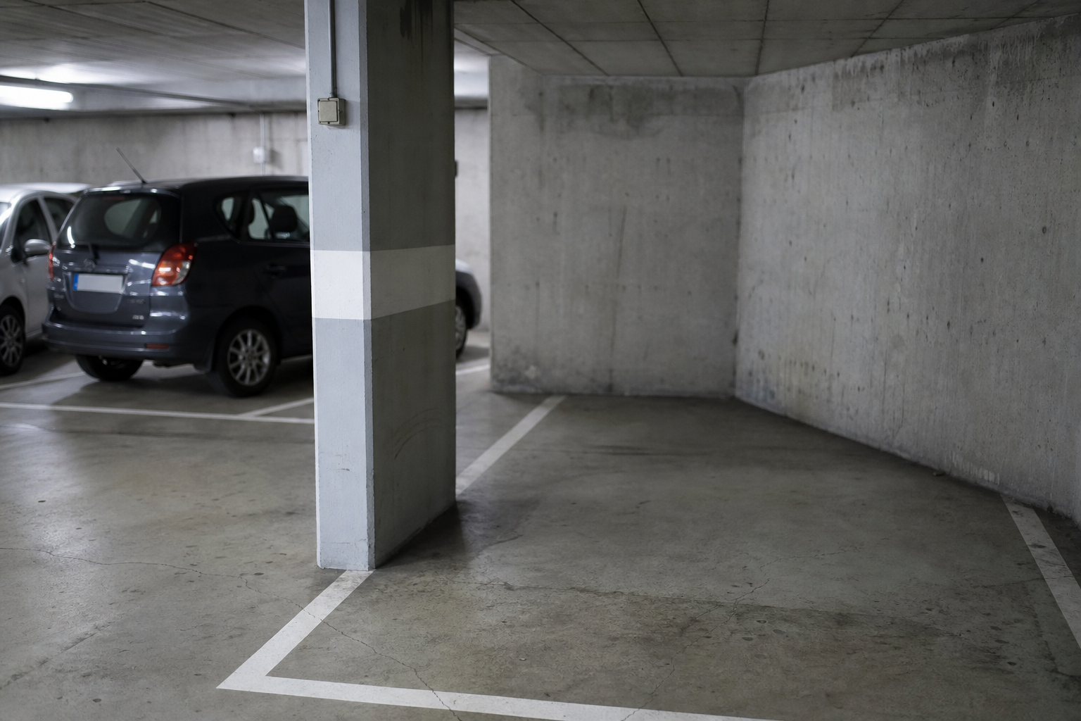Place de parking vide à côté d'un pilier en béton