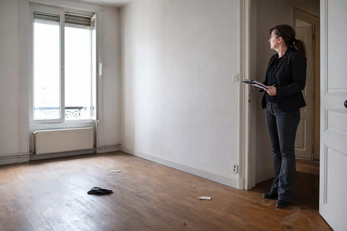 Personne debout contrôlant un robot aspirateur