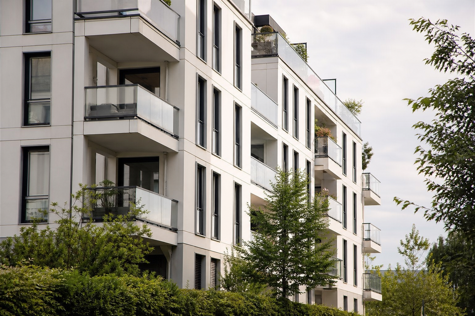 Façade d'immeuble moderne avec balcons et arbres